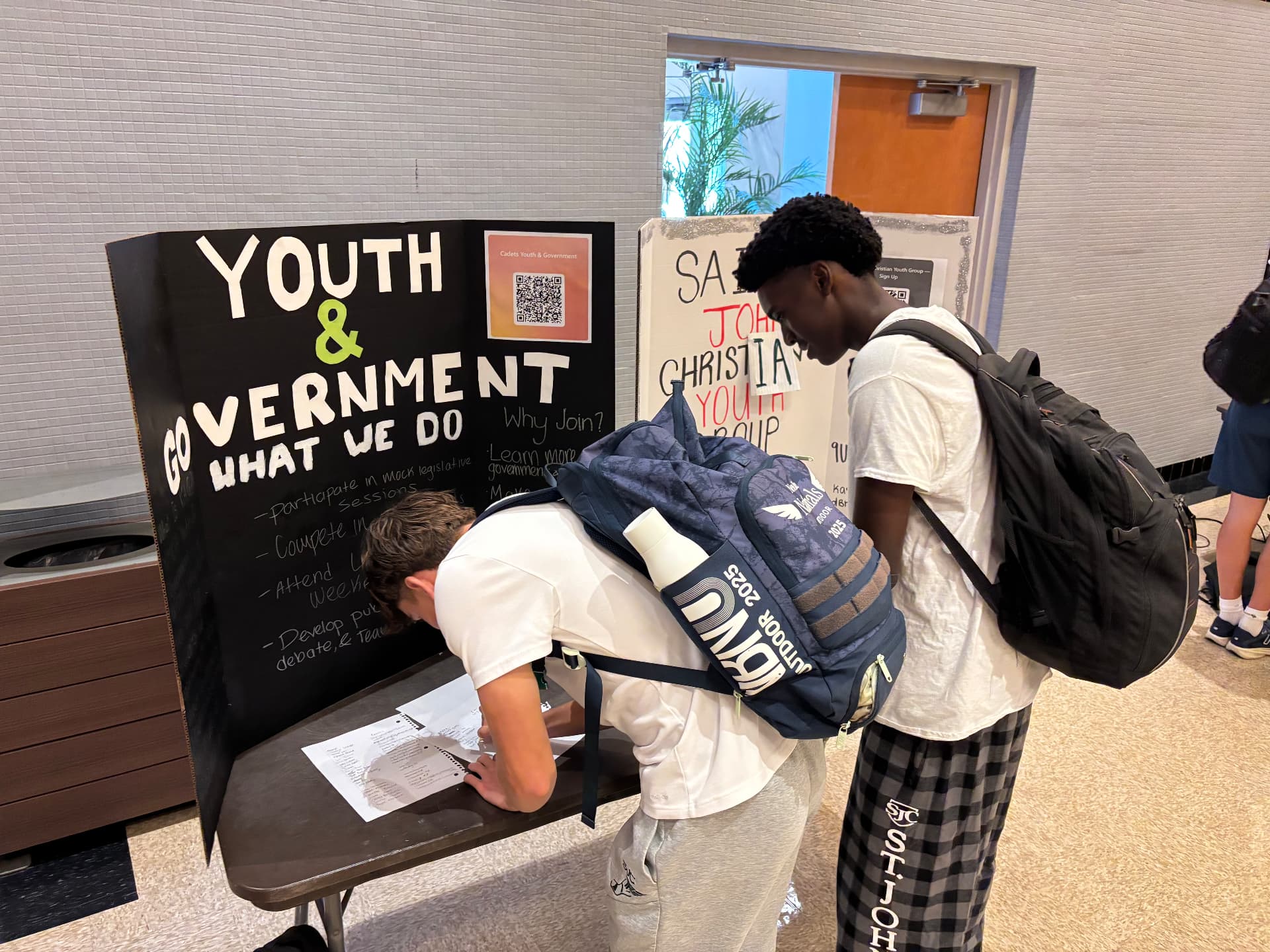 Students signing up at the Youth & Government club table during a school activity fair