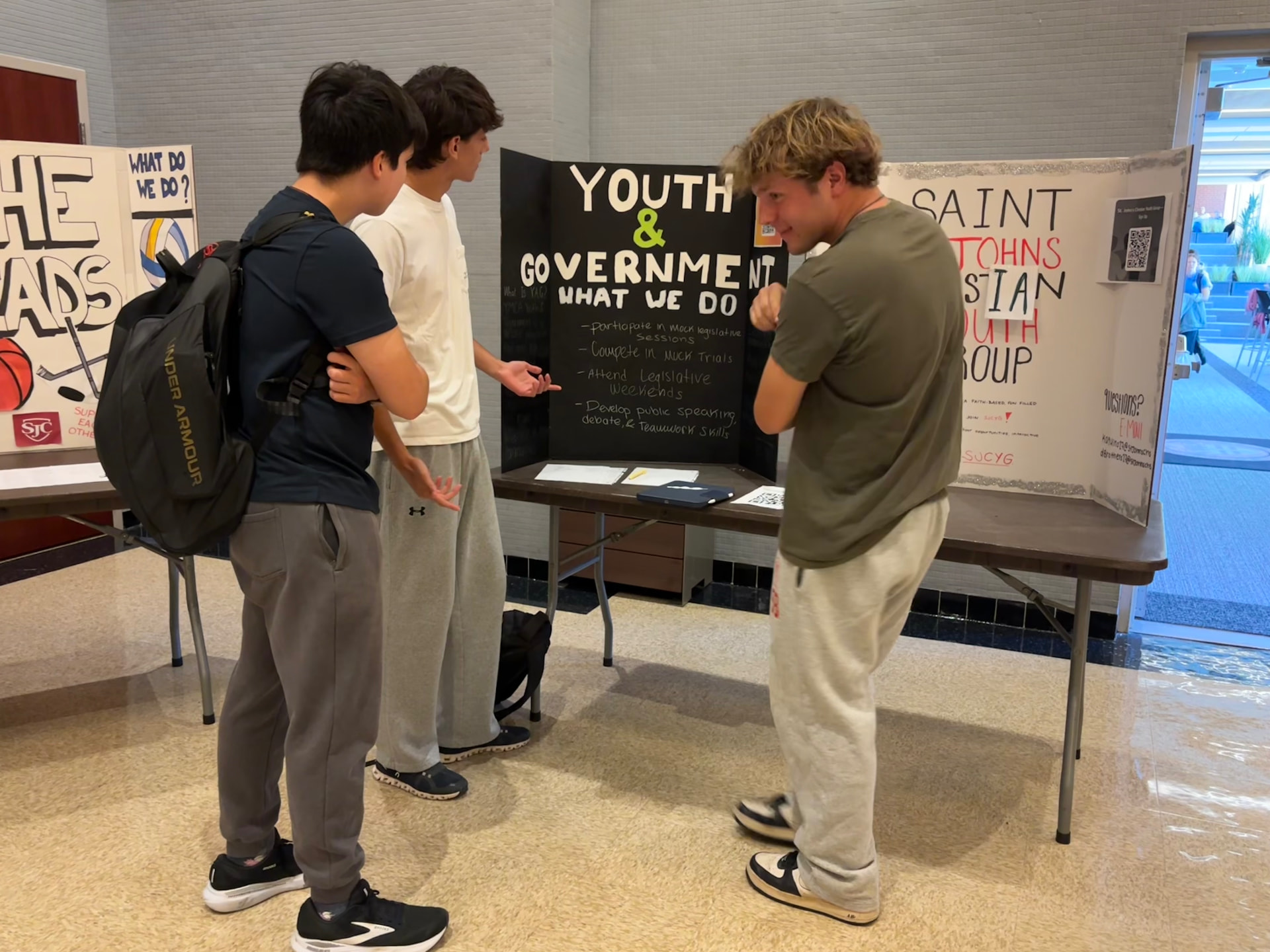 Students talking at the Youth & Government club booth during a school activity fair